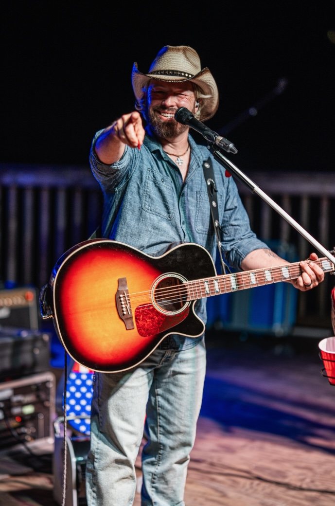 Joshua Alan pointing at the crowd with a red Solo cup on the mic stand